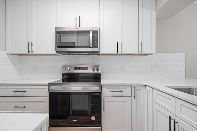 48 4th Ave, Shalimar, FL 32579 - kitchen featuring stainless steel appliances, tasteful backsplash, light stone counters, and white cabinets