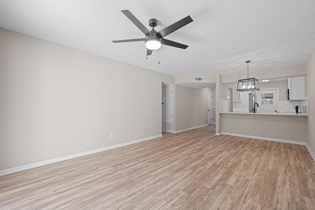 48 4th Ave, Shalimar, FL 32579 - unfurnished living room featuring light wood finished floors, ceiling fan, and a chandelier
