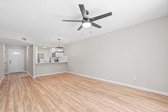 48 4th Ave, Shalimar, FL 32579 - unfurnished living room featuring light wood-style flooring, a ceiling fan, and a chandelier
