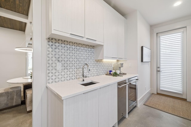 21 Scuttle Hole Rd, Santa Rosa Beach, FL 32459 - kitchen featuring decorative backsplash, light countertops, white cabinetry, modern cabinets, and concrete floors