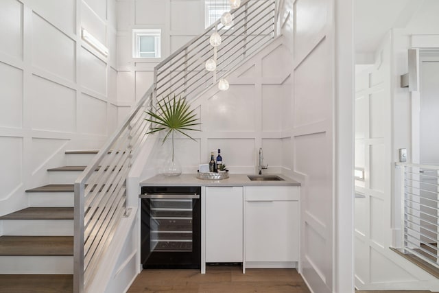 21 Scuttle Hole Rd, Santa Rosa Beach, FL 32459 - indoor wet bar with a decorative wall, beverage cooler, stairs, and wood finished floors