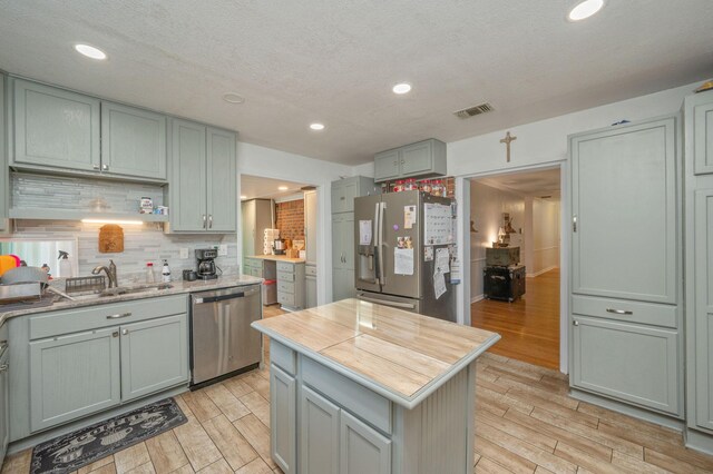22 James Ave, Shalimar, FL 32579 - kitchen with stainless steel appliances, light wood-style flooring, decorative backsplash, a center island, and recessed lighting