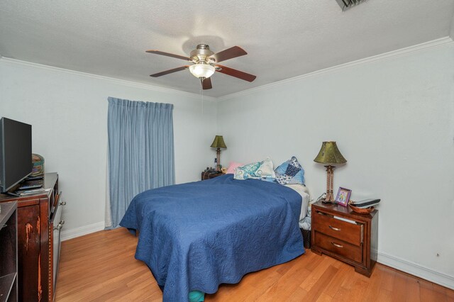 22 James Ave, Shalimar, FL 32579 - bedroom with crown molding, light wood-style flooring, ceiling fan, and a textured ceiling