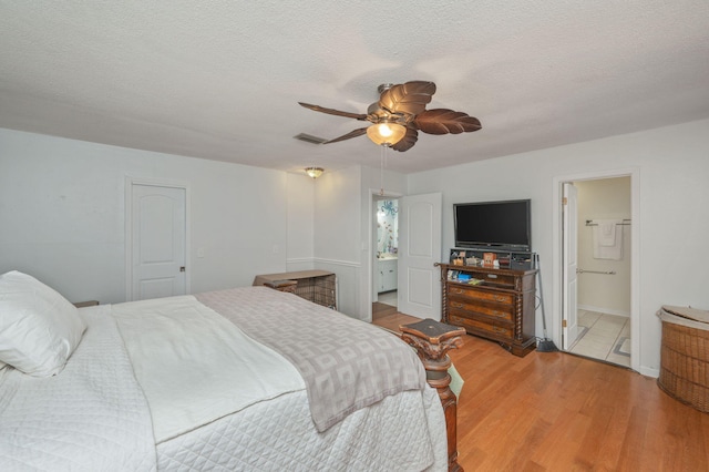 22 James Ave, Shalimar, FL 32579 - bedroom with wood finished floors, a textured ceiling, a ceiling fan, and ensuite bath