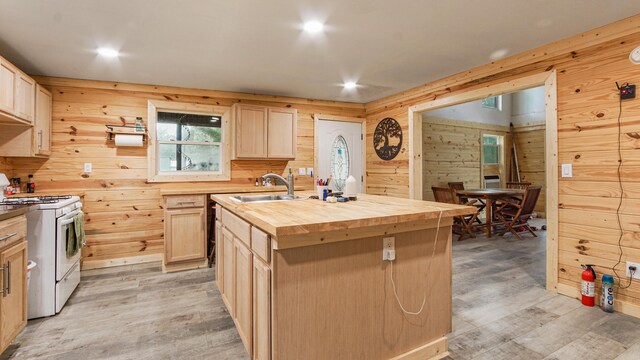 70 River Loop, Ponce De Leon, FL 32455 - kitchen featuring white gas range oven, butcher block countertops, light brown cabinets, wooden walls, and light wood-style flooring
