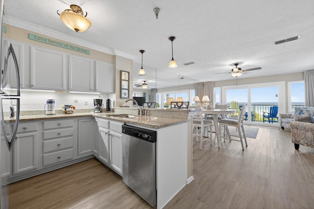 1700 Scenic Highway 98 Unit 101, Destin, FL 32541 - kitchen with dishwasher, ceiling fan, open floor plan, a peninsula, and light wood-style floors