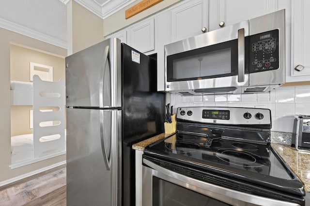 1700 Scenic Highway 98 Unit 101, Destin, FL 32541 - kitchen featuring appliances with stainless steel finishes, crown molding, tasteful backsplash, white cabinetry, and light stone countertops