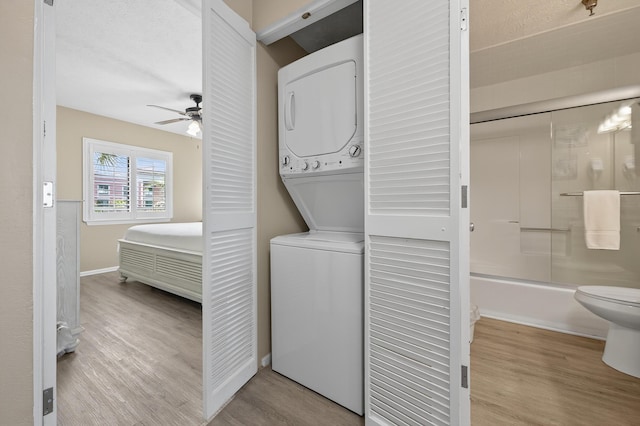 1700 Scenic Highway 98 Unit 101, Destin, FL 32541 - washroom with stacked washer / dryer, a ceiling fan, and wood finished floors