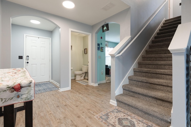 4605 Plover Dr, Crestview, FL 32539 - entryway with arched walkways, stairs, and light wood finished floors