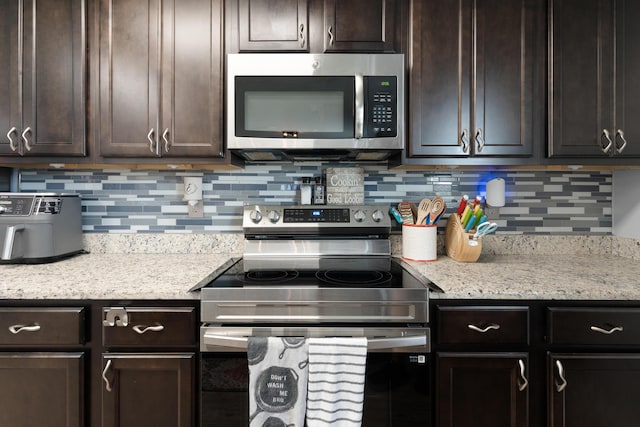 4605 Plover Dr, Crestview, FL 32539 - kitchen with appliances with stainless steel finishes, dark brown cabinetry, and backsplash