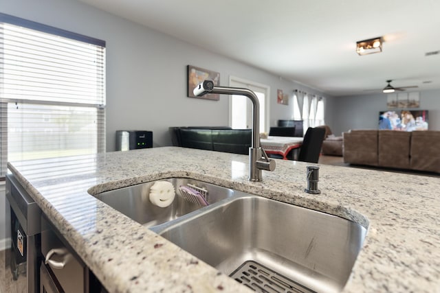 4605 Plover Dr, Crestview, FL 32539 - kitchen with open floor plan, ceiling fan, light stone countertops, and wood finished floors