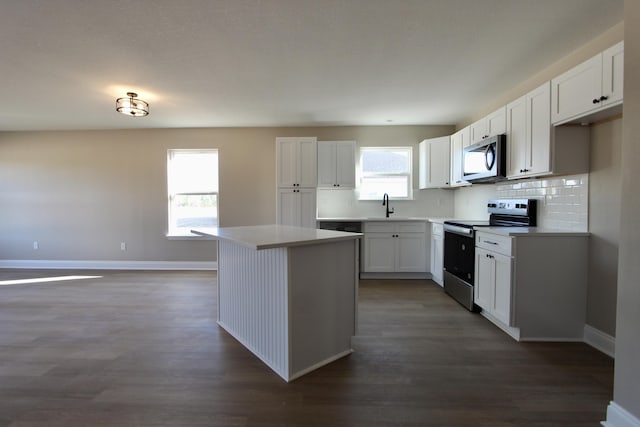 5367 Highview Dr, Crestview, FL 32539 - kitchen with appliances with stainless steel finishes, white cabinets, decorative backsplash, dark wood finished floors, and a center island
