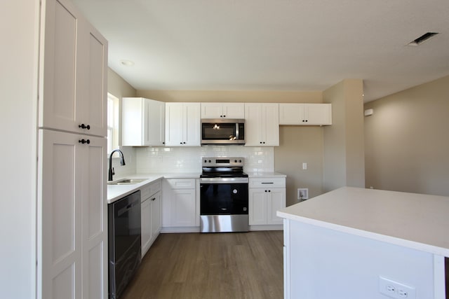 5367 Highview Dr, Crestview, FL 32539 - kitchen with stainless steel appliances, light wood finished floors, tasteful backsplash, and white cabinets