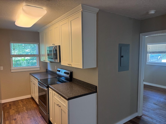 5148 Cavalier Dr, Crestview, FL 32539 - kitchen with stainless steel appliances, electric panel, a textured ceiling, dark countertops, and dark wood-style flooring