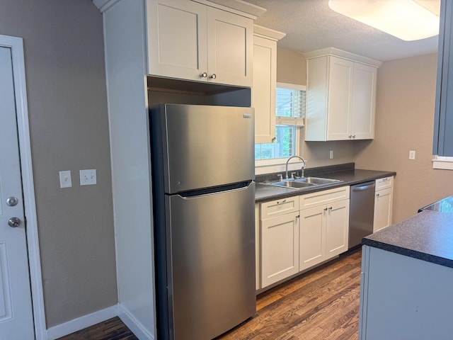 5148 Cavalier Dr, Crestview, FL 32539 - kitchen with stainless steel appliances, dark countertops, dark wood finished floors, and a textured ceiling