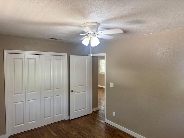 5148 Cavalier Dr, Crestview, FL 32539 - unfurnished bedroom featuring dark wood-style flooring, a closet, a textured ceiling, and a ceiling fan