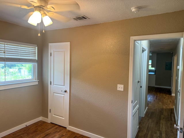 5148 Cavalier Dr, Crestview, FL 32539 - unfurnished bedroom with dark wood-type flooring, a textured wall, and ceiling fan