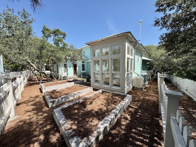 209 Dune Crest Ln, Panama City Beach, FL 32413 - rear view of property with a fenced backyard and a vegetable garden