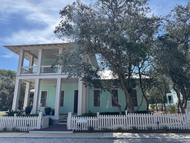 209 Dune Crest Ln, Panama City Beach, FL 32413 - view of front facade featuring a balcony, a porch, a fenced front yard, and ceiling fan