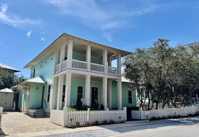 209 Dune Crest Ln, Panama City Beach, FL 32413 - view of front facade featuring a balcony, a porch, a fenced front yard, and decorative driveway
