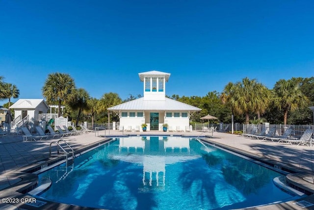 209 Dune Crest Ln, Panama City Beach, FL 32413 - community pool featuring a patio and view of wooded area