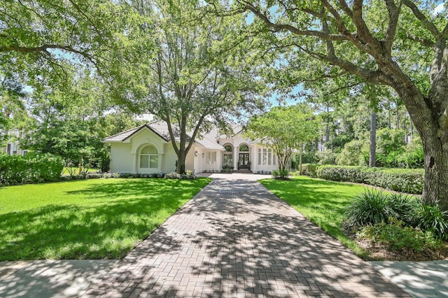 4564 Nautical Ct, Destin, FL 32541 - view of front facade featuring stucco siding, decorative driveway, and a front lawn
