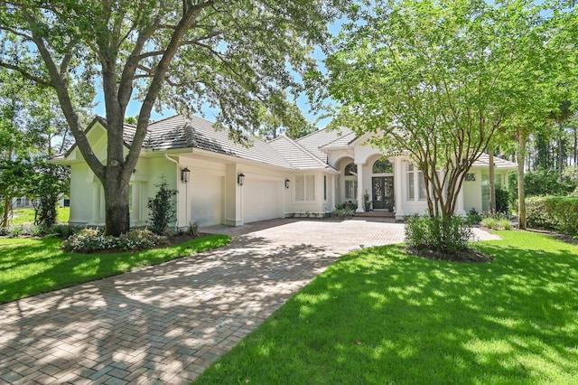 4564 Nautical Ct, Destin, FL 32541 - view of front of house with an attached garage, decorative driveway, a front lawn, french doors, and stucco siding