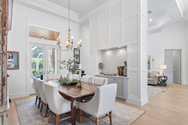4564 Nautical Ct, Destin, FL 32541 - dining area featuring ornamental molding, a towering ceiling, light wood-style flooring, and a chandelier