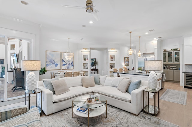4564 Nautical Ct, Destin, FL 32541 - living area with a ceiling fan, light wood finished floors, wine cooler, recessed lighting, and crown molding