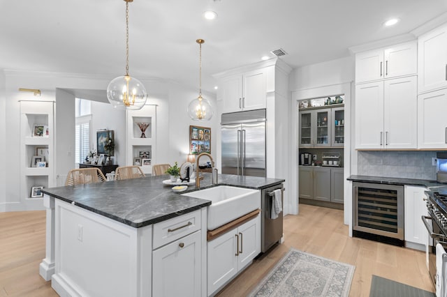 4564 Nautical Ct, Destin, FL 32541 - kitchen featuring wine cooler, a kitchen island with sink, white cabinetry, light wood finished floors, and recessed lighting