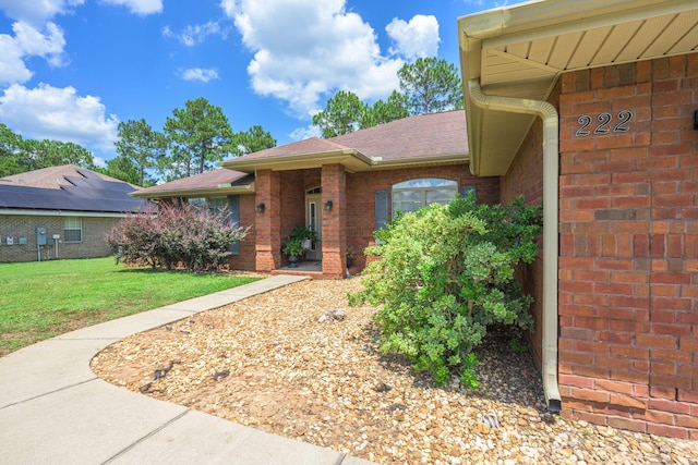 222 Raptor Dr, Crestview, FL 32536 - entrance to property with brick siding, a yard, and a shingled roof