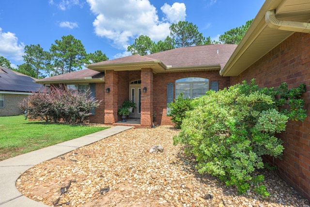 222 Raptor Dr, Crestview, FL 32536 - property entrance featuring brick siding, roof with shingles, and a yard