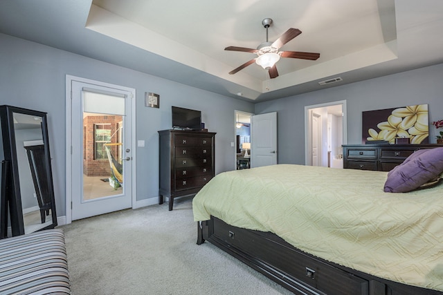 222 Raptor Dr, Crestview, FL 32536 - bedroom featuring a tray ceiling, light carpet, access to exterior, and a ceiling fan