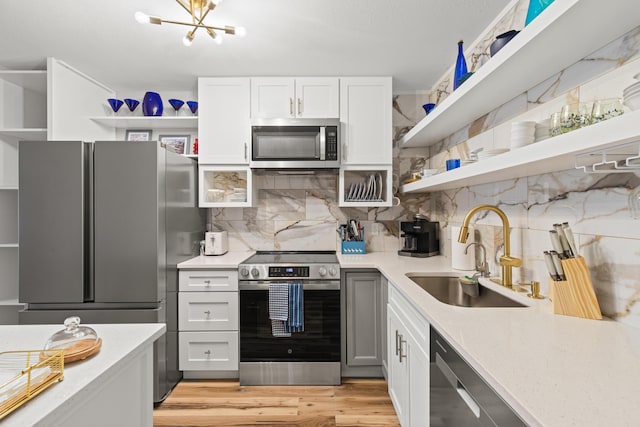 210 Pelham Rd Unit 211B, Fort Walton Beach, FL 32547 - kitchen featuring appliances with stainless steel finishes, open shelves, light countertops, and backsplash