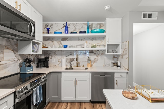 210 Pelham Rd Unit 211B, Fort Walton Beach, FL 32547 - kitchen with appliances with stainless steel finishes, open shelves, and decorative backsplash