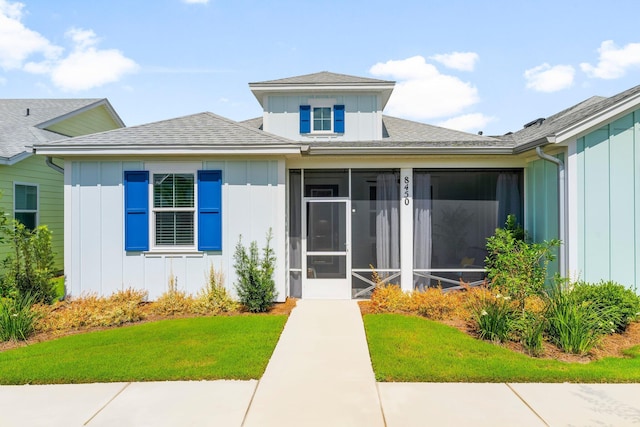 8450 Dreams Float Ct, Panama City Beach, FL 32413 - entrance to property featuring board and batten siding, a yard, and a shingled roof