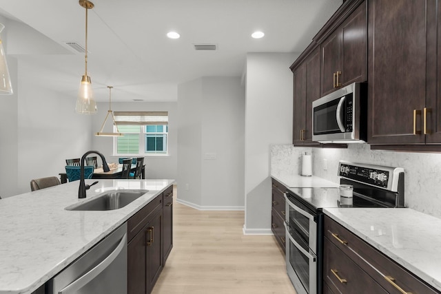 8450 Dreams Float Ct, Panama City Beach, FL 32413 - kitchen with stainless steel appliances, light wood-type flooring, pendant lighting, light stone counters, and recessed lighting