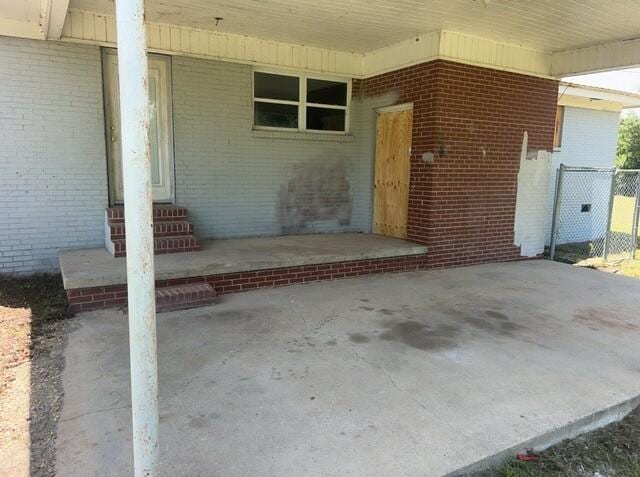 2032 Brogdon St, Grand Ridge, FL 32442 - view of exterior entry featuring a carport and brick siding