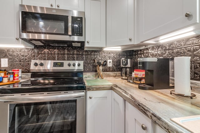 2141 C Shelby Ln, Westville, FL 32464 - kitchen featuring stainless steel appliances, white cabinets, and tasteful backsplash
