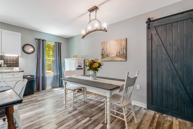 2141 C Shelby Ln, Westville, FL 32464 - dining space with light wood-style flooring, a chandelier, and a barn door