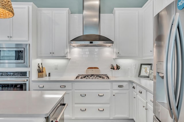 654 Flatwoods Forest Loop, Santa Rosa Beach, FL 32459 - kitchen featuring stainless steel appliances, wall chimney range hood, light countertops, and white cabinetry