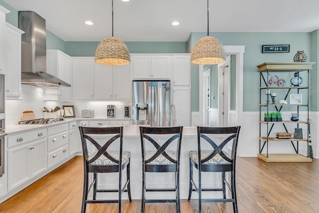 654 Flatwoods Forest Loop, Santa Rosa Beach, FL 32459 - kitchen with wall chimney range hood, light countertops, stainless steel fridge with ice dispenser, light wood-type flooring, and wainscoting