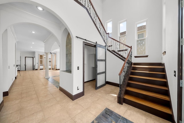 3929 Indian Springs Rd, Panama City, FL 32404 - staircase featuring crown molding, tile patterned flooring, recessed lighting, decorative columns, and arched walkways