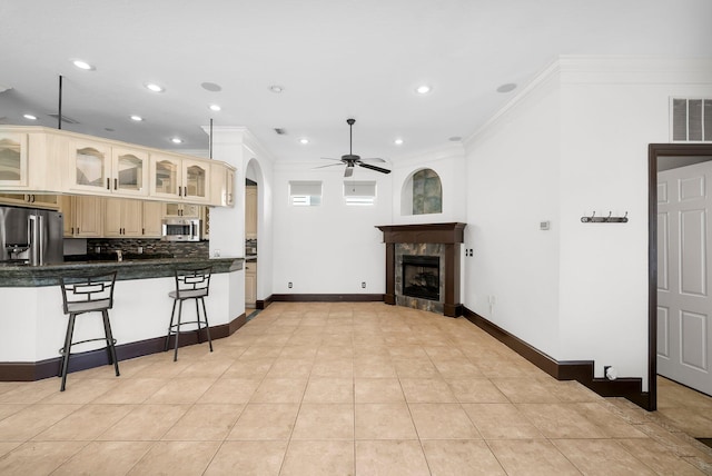 3929 Indian Springs Rd, Panama City, FL 32404 - kitchen with ceiling fan, dark countertops, a breakfast bar area, stainless steel appliances, and a tile fireplace