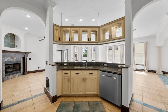 3929 Indian Springs Rd, Panama City, FL 32404 - kitchen with light tile patterned floors, crown molding, stainless steel dishwasher, a fireplace, and arched walkways