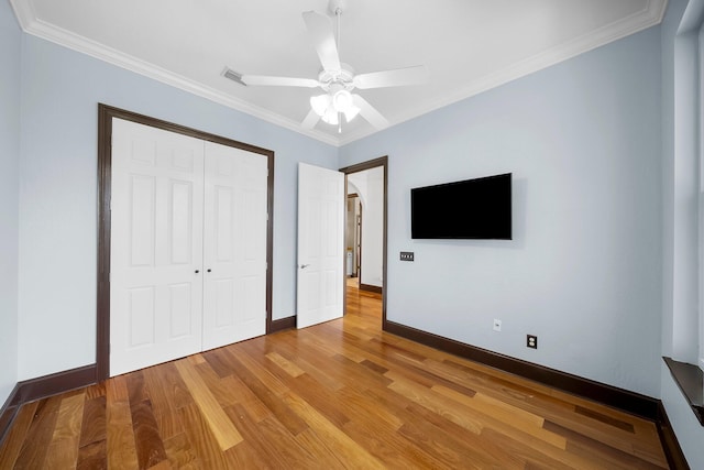 3929 Indian Springs Rd, Panama City, FL 32404 - unfurnished bedroom featuring a closet, light wood-style floors, ornamental molding, arched walkways, and a ceiling fan