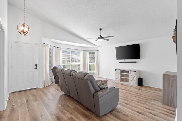 277 Limestone Cir, Crestview, FL 32539 - living room with lofted ceiling, a ceiling fan, light wood-type flooring, a textured ceiling, and a chandelier