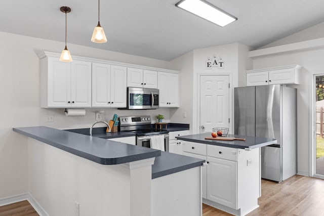 277 Limestone Cir, Crestview, FL 32539 - kitchen with dark countertops, appliances with stainless steel finishes, a peninsula, light wood finished floors, and white cabinetry