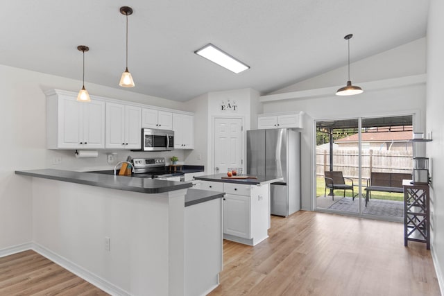 277 Limestone Cir, Crestview, FL 32539 - kitchen featuring dark countertops, stainless steel appliances, vaulted ceiling, light wood-style floors, and white cabinetry
