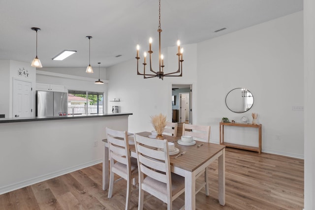 277 Limestone Cir, Crestview, FL 32539 - dining area featuring light wood finished floors, vaulted ceiling, and a chandelier